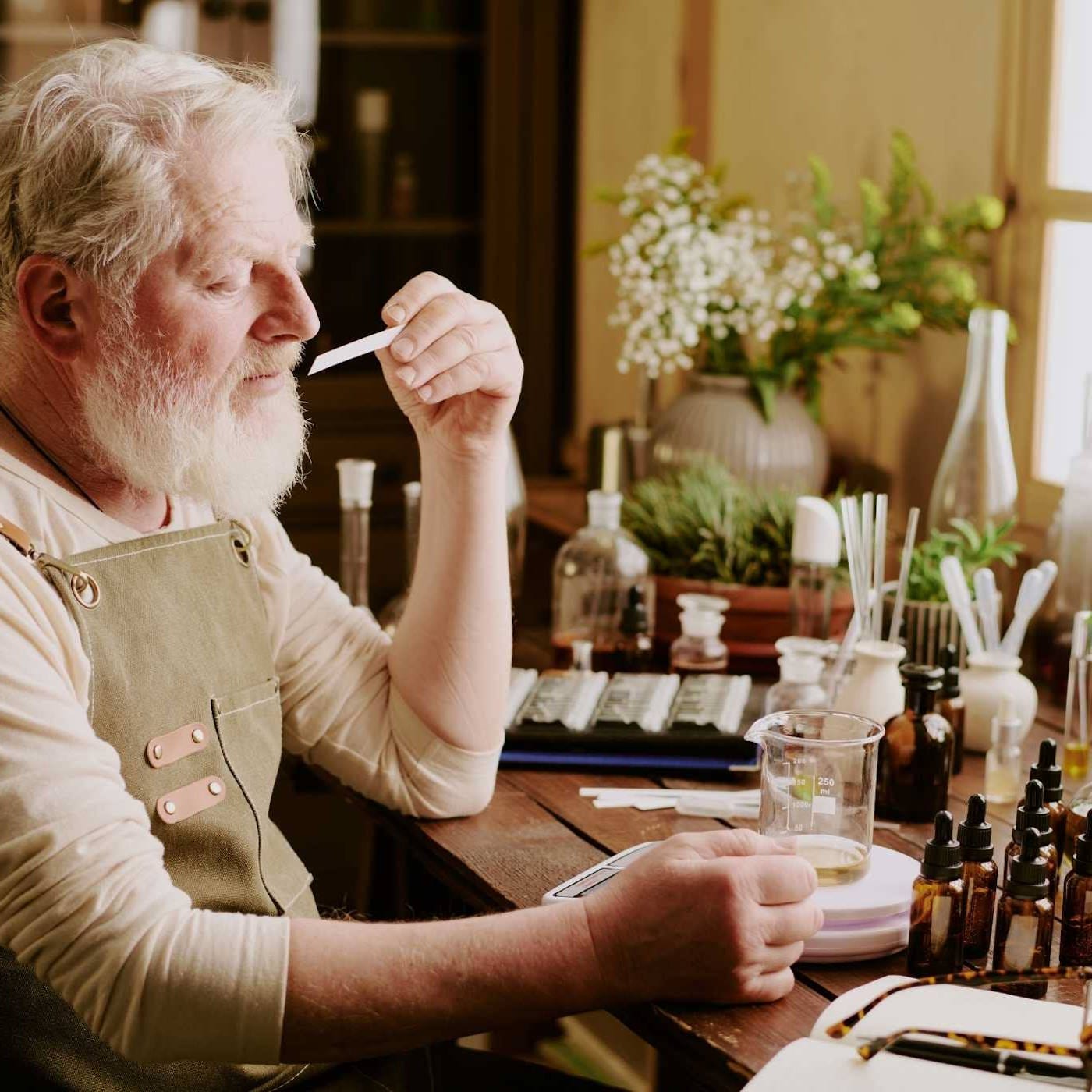 An experienced perfumer expertly blending high-quality ingredients to create a luxurious fragrance, showcasing the craftsmanship and artistry of perfume-making in Grasse, France