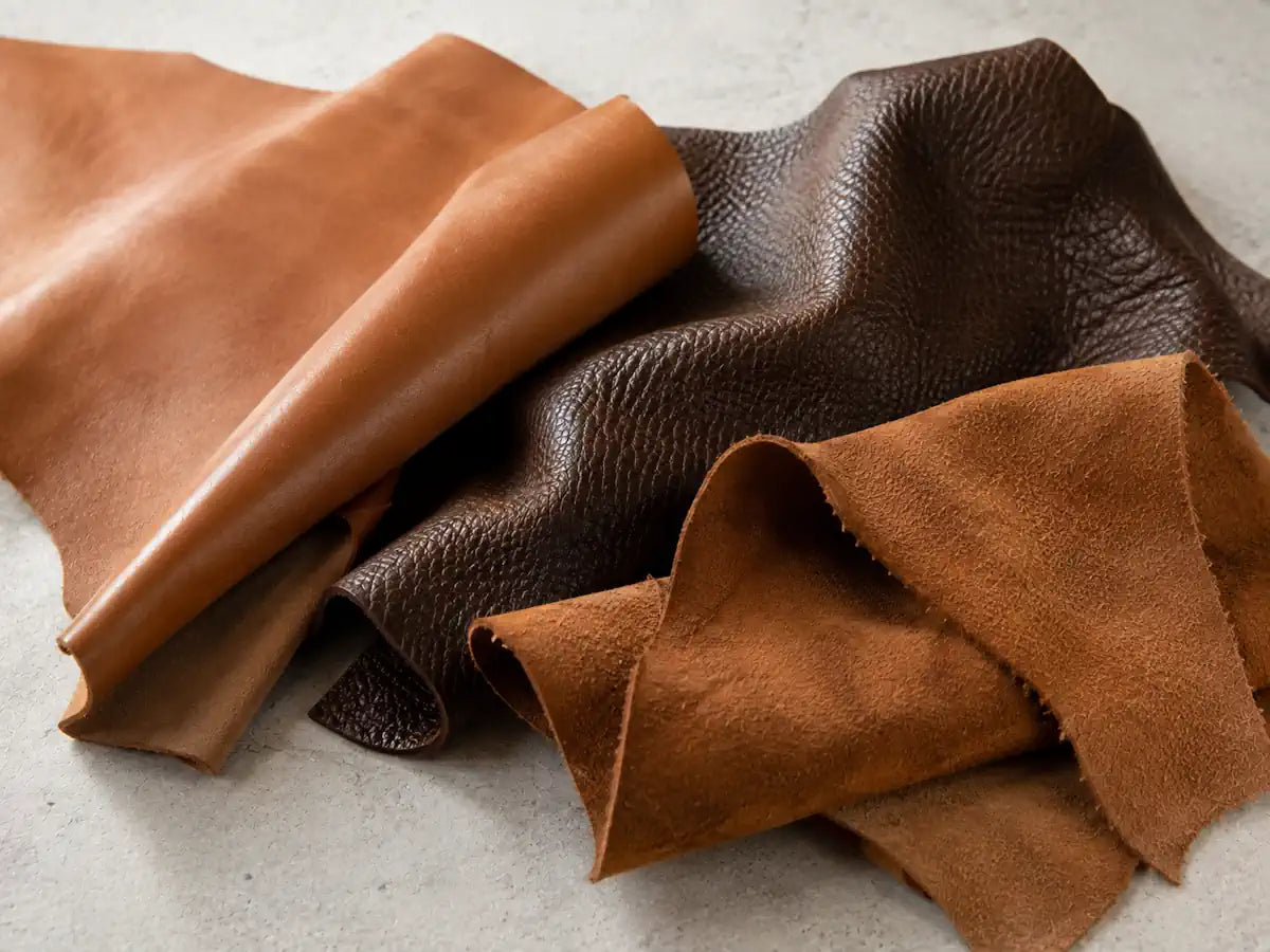 Natural smooth leather, grained leather and suede textures on a light cool-stone background