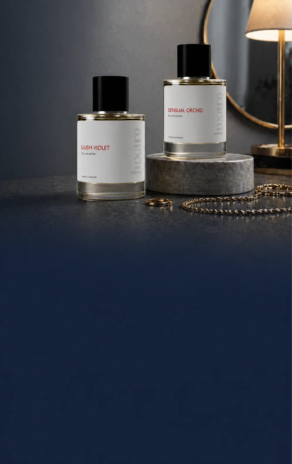 Two luxury perfume bottles at the top, one elevated on a marble block, fading into a deep blue gradient background below