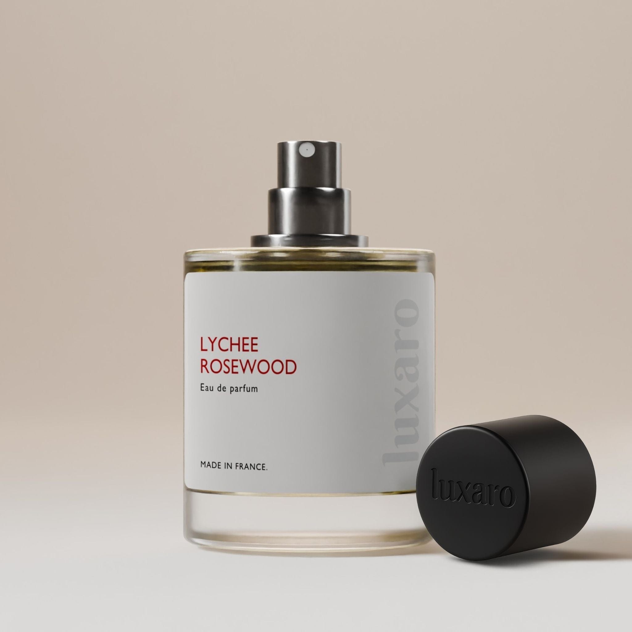 Luxaro Lychee Rosewood perfume bottle with cap removed, revealing the mysterious fragrance inside, inspired by Delina dupe – featuring notes of lychee, Turkish rose, musk and vanilla, luxury fragrance alternative made in France.